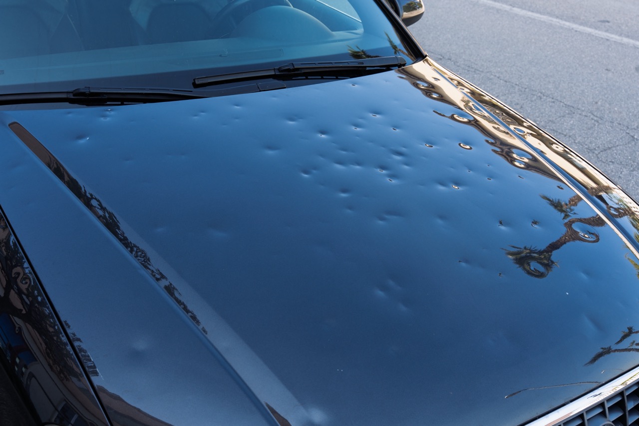 image of car hood hit by hail. storm damage
